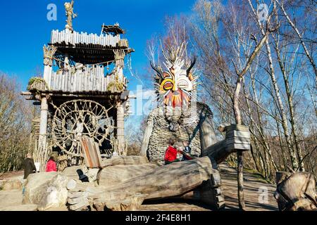 (210321) -- BOOM, 21. März 2021 (Xinhua) -- Kinder spielen um einen Troll im Waldpark De Schorre in Boom, Belgien, 20. März 2021. Der dänische Künstler Thomas Dambo und sein Team bauten 2019 im Waldpark De Schorre in Nordbelgien sieben riesige 'Trolle' aus zurückgewonnenen Hölzern. Diese riesigen Holzskulpturen sind im Wald verstreut. Die Generalversammlung der Vereinten Nationen hat den 21. März zum Internationalen Tag der Wälder ausgerufen, der die Bedeutung aller Arten von Wäldern und die Notwendigkeit der Erhaltung und Pflege der Wälder der Welt feiert und für sie sensibilisiert. Dieses Jahr th Stockfoto