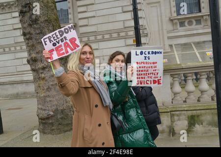 Demonstranten halten Plakate, die ihre Meinung während der Demonstration ausdrücken. Tausende von Menschen hatten sich illegal zu einer Demonstration gegen die Sperre in London versammelt und damit gegen die nationalen Sperrregeln verstoßen. Stockfoto