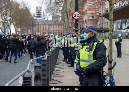 London, Großbritannien. März 2021, 20th. Polizeibeamte beobachten Protestierende, während sie vor Scotland Yard, dem Hauptquartier der Metropolitan Police, während der World Wide Rally for Freedom vorbeikommen.bei einer World Wide Rally for Freedom veranstalteten Activisten und Menschen eine Demonstration gegen die aktuellen Einschränkungen im Zusammenhang mit der Coronavirus-Krankheit (COVID-19). Kredit: SOPA Images Limited/Alamy Live Nachrichten Stockfoto