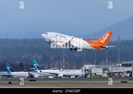 Richmond, British Columbia, Kanada. März 2021, 5th. Ein Air North Boeing 737-500 Jet (C-GANH) hebt vom Vancouver International Airport ab. Im Hintergrund stehen mehrere WestJet-Flugzeuge auf dem Asphalt des Flughafens. Quelle: Bayne Stanley/ZUMA Wire/Alamy Live News Stockfoto