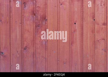 Textur einer Holzwand aus roten Lamellen. Stockfoto