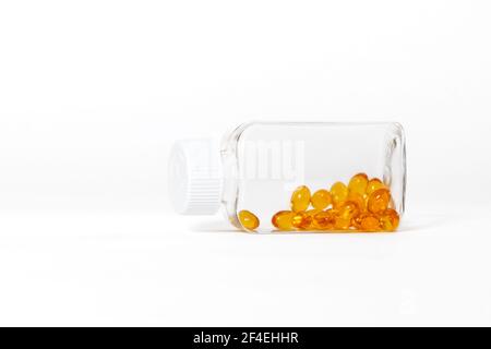 Gelbe Farbe Fischöl Kapseln in Glasflasche auf weißem Hintergrund. Stockfoto