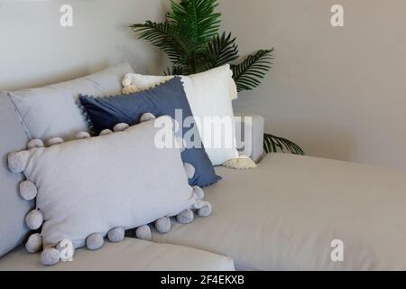 Eine gemütliche Ecke auf einem Sofa in einem Wohnzimmer mit vielen Kissen in neutralen Farbtönen. Stockfoto