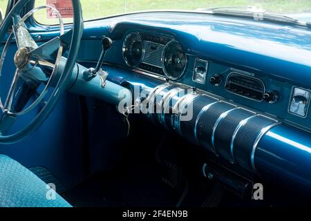 Armaturenbrett und Innenraum eines restaurierten klassischen 1955 Buick mit Knöpfen und Lehren und Lenkrad in blau t passen auf das Äußere. Stockfoto
