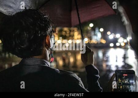 Während einer regierungsfeindlichen Demonstration in Bangkok hält ein prodemokratischer Protestler einen Regenschirm in der Hand, während er vor Polizeibeamten steht. Tausende von prodemokratischen Demonstranten versammelten sich in der Nähe des Großen Palastes in Sanam Luang und forderten den Rücktritt des thailändischen Premierministers und die Reform der Monarchie. Die Demonstranten verurteilten auch die Anwendung des Gesetzes von Lese majeste gemäß Abschnitt 112 des Strafgesetzbuches. Der von REDEM (Restart Democracy) organisierte Protest endete mit mehreren Zusammenstößen, dem Einsatz von Wasserwerfern, Tränengas und Gummigeschossen, die mehrere Verletzte hinterließen. Stockfoto