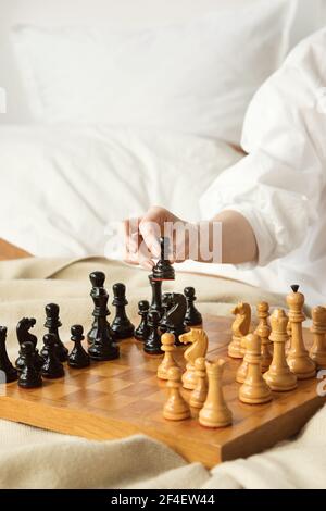 Schachspielerin Frau Lernt Schacheröffnung, Indem Sie Mit Sich Selbst Spielt. Schwarzer Bauer Einen Schritt Vorwärts. Schachbrett Aus Holz Mit Schachfiguren Auf Hellem Hintergrund. Strategie Board Spiel Gespielt. Nahaufnahme Stockfoto
