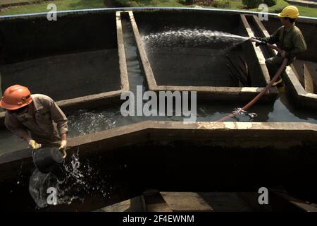 Jakarta, Indonesien. 18. Juni 2021 Arbeiter, die Wartungsarbeiten an der Quellwasseraufbereitungsanlage durchführen, einem Teil des Wasseraufbereitungskomplexes, der von einem der Wasserversorger der Jakarta, Palyja, betrieben wird, dem Eigentümer der Wasserkonzession für den westlichen Teil der indonesischen Hauptstadt. Stockfoto