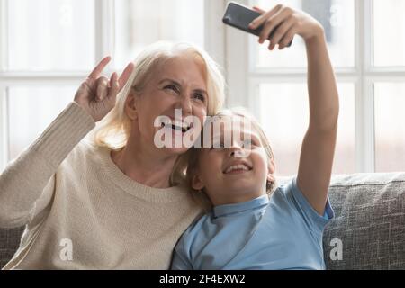 Lächelnd Senior Oma und Enkelin nehmen Selfie auf Zelle Stockfoto