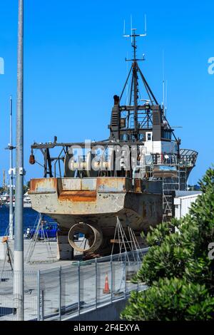 Ein Fischerboot nach dem aus dem Wasser für die Wartung gehoben. Die Propellerverkleidung und die Netzwinden am Heck sind sichtbar Stockfoto