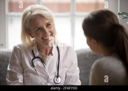 Lächelnde Ärztin sprechen mit dem Patienten in der Klinik Stockfoto