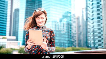Junge asiatische Frau mit elektronischen Gerät in der modernen Stadt - Technologie Lifestyle-Konzept mit Mädchen Spaß mit pc-Tablet Gerät Stockfoto