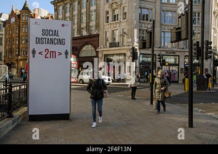 London, Großbritannien - 26. Februar 2021: Fußgänger, viele mit Gesichtsmasken, im Einkaufsviertel Oxford Circus in Westminster, im Zentrum von London. Stockfoto