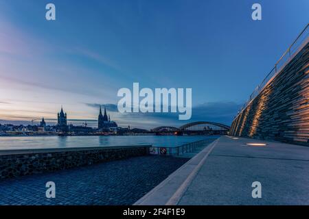 Rheinpromenade in Köln mit Blick auf den Kölner Dom zur blauen Stunde, Deutschland. Stockfoto