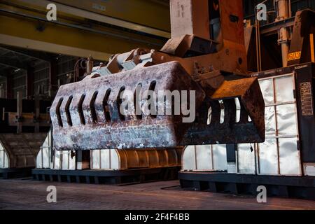 Pavlodar, Kasachstan - Mai 05 2012: Aluminium-Elektrolyse-Anlage. Schlackenhandling Kraneimer auf der Vorderseite und glänzende Elektrolysebäder auf dem Hintergrund. Stockfoto