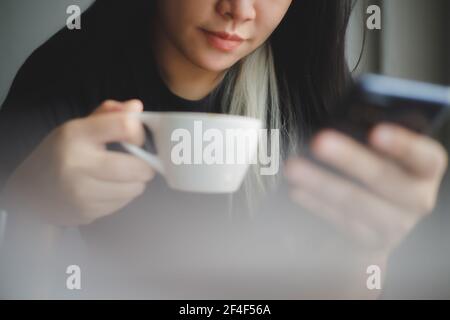 Frauen trinken gerne Kaffee in einem Café, während sie Kaffee trinken Tasse heißen Cappuccino Stockfoto