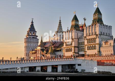 = Architekturensemble des Izmailovo Kremls bei Sonnenuntergang = der Blick vom Parkplatz auf die Eingangsbrücke, Türme und Gebäude von schöner Architektur Stockfoto