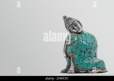 Nahaufnahme einer gussmetallenen Figur eines ruhenden Buddha, isoliert auf weißem Hintergrund Stockfoto
