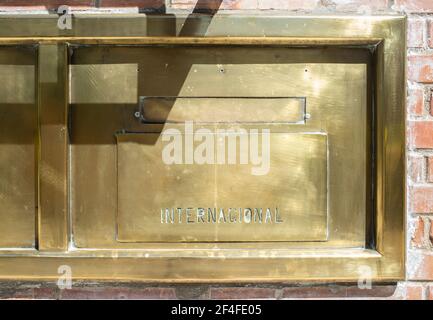 Postamt goldener Messing Briefkasten. Eingravierte Wort in Spanisch International Stockfoto