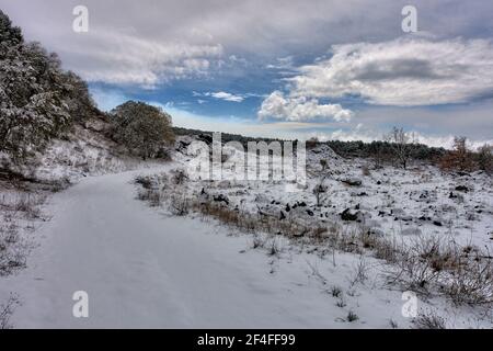 Winterlandschaft in sizilien mit schneebedeckten Weg und alt Lava Ebene gegen dramatischen Himmel Stockfoto