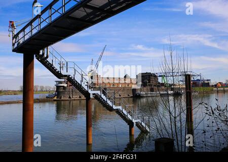 Krefeld (Ürdingen) - März 1. 2021: Blick auf alte Steg-Stahltreppe mit Rhein- und Binnenhafen-Fabrikgebäude im Hintergrund (Schwerpunkt Treppenhaus) Stockfoto