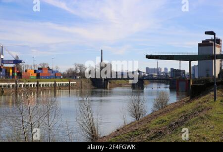 Krefeld (Ürdingen) - März 1. 2021: Blick auf alten Binnenschiffhafen am rhein mit Kran, Wasserschiff und Fabrikgebäude Stockfoto