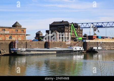 Krefeld (Ürdingen) - März 1. 2021: Blick auf alten Binnenschiffhafen am rhein mit Kran, Wasserschiff und Fabrikgebäude Stockfoto