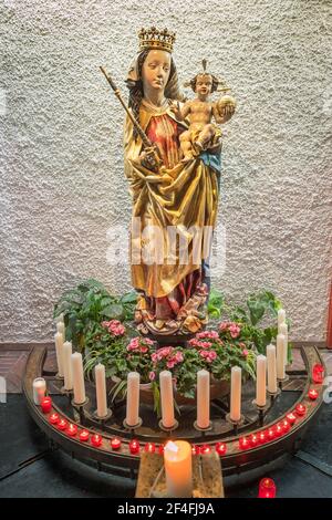 Figur der Jungfrau Maria mit Jesuskind und Opferkerzen, Kirche St. Johannes der Täufer, Ismaning, Oberbayern, Bayern, Deutschland Stockfoto