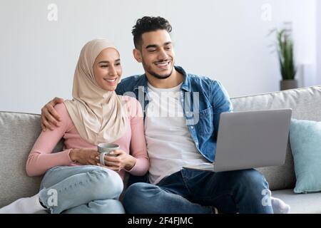 Entspannte arabische Familie beim Film auf dem Laptop Stockfoto