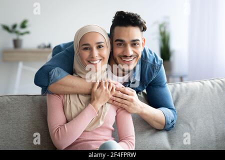 Portrait eines liebenden muslimischen Paares, das sich zu Hause umarmt Stockfoto