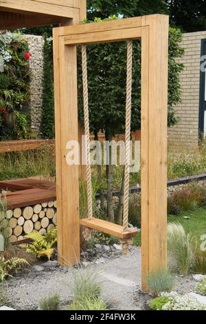 Ein starkes Seil und hölzerne Gartenschaukel. Stockfoto