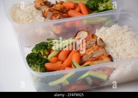 Gesunde ausgewogene Lunchboxen. Gegrilltes Hähnchen, Karotten, Gurken, Brokkoli und weißer Reis. Lunchboxen mit Lebensmitteln bereit für die Arbeit oder die Schule zu gehen. Aus Stockfoto