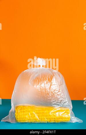 Maiskolben in einer Plastiktüte auf einem hellen Hintergrund. Stockfoto