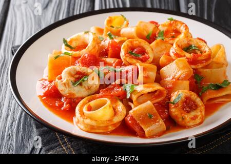Klassische Pasta Calamarata mit Tintenfisch-Sauce Italienische Rezept Nahaufnahme in einem Teller auf dem Tisch. Horizontal Stockfoto