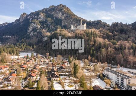 Luftdrohnenaufnahme des malerischen Schlosses Neuschwanstein auf einem verschneiten Hügel Im Winter Sonnenlicht in Deutschland Stockfoto