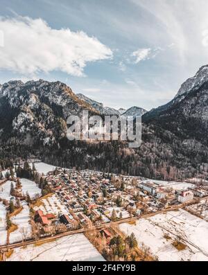 Luftdrohnenaufnahme des malerischen Schlosses Neuschwanstein auf einem verschneiten Hügel Im Winter Sonnenlicht in Deutschland Stockfoto
