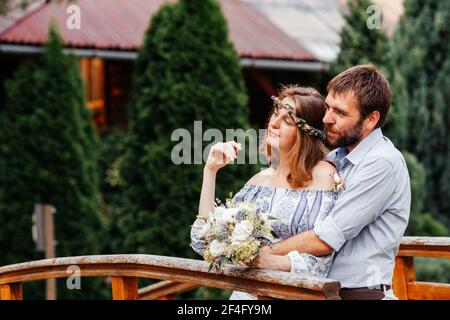 Eclectic rustikalen Hochzeitspaar stehen auf der Brücke Stockfoto