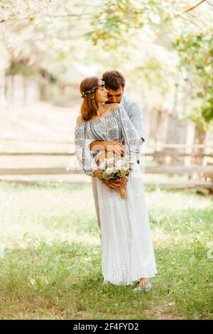 Eklektisches rustikales Hochzeitspaar. Intime Zeremonie im Hinterhof Stockfoto