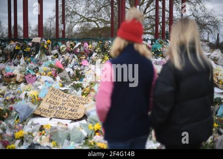 Menschen, die Blumengebete ansehen, die am Bandstand in Clapham Common, London, für Sarah Everard hinterlassen wurden. PC Wayne Couzens, 48, erschien im Old Bailey in London und wurde wegen der Entführung und Ermordung des 33-Jährigen angeklagt. Bilddatum: Sonntag, 21. März 2021. Stockfoto