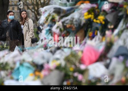 Menschen, die Blumengebete ansehen, die am Bandstand in Clapham Common, London, für Sarah Everard hinterlassen wurden. PC Wayne Couzens, 48, erschien im Old Bailey in London und wurde wegen der Entführung und Ermordung des 33-Jährigen angeklagt. Bilddatum: Sonntag, 21. März 2021. Stockfoto