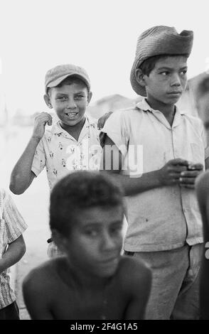 Porträt von drei Kindern, eines mit Cowboyhut, Biran, Kuba, Holguin-Provinz, 1963. Aus der Sammlung Deena Stryker Photographs. () Stockfoto