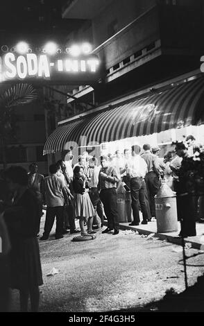 Nachtansicht einer großen Anzahl von Gönnern, die vor einem Eisstand in Vedado, Havanna, Kuba, 1964 stehen. Aus der Sammlung Deena Stryker Photographs. () Stockfoto