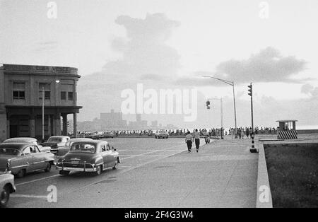 Breite Aufnahme von Fußgängern und Autos auf der Malecon (Avenida de Maceo), Havanna, Kuba, 1964. Aus der Sammlung Deena Stryker Photographs. () Stockfoto