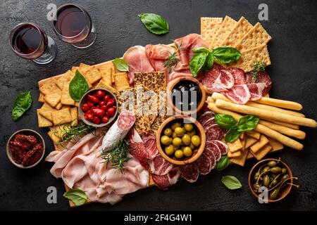 Vorspeisen mit verschiedenen Antipasti, Wurstwaren, Snacks und Rotwein. Wurst, Schinken, Tapas, Oliven und Cracker für Buffet-Party. Draufsicht, flach liegend Stockfoto
