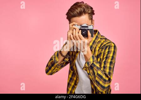 Junger Fotograf mit Kamera, rosa Hintergrund Stockfoto