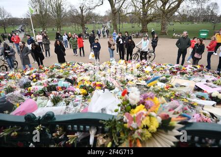 Menschen, die Blumengebete ansehen, die am Bandstand in Clapham Common, London, für Sarah Everard hinterlassen wurden. PC Wayne Couzens, 48, erschien im Old Bailey in London und wurde wegen der Entführung und Ermordung des 33-Jährigen angeklagt. Bilddatum: Sonntag, 21. März 2021. Stockfoto