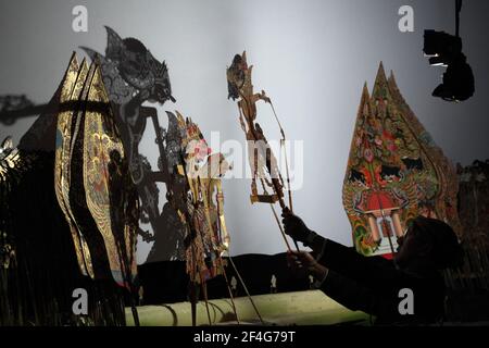 Marionettenmeister (Dalang) Manteb Sudharsono führt die Wayang-Kulit-Performance "Sudamala" im Sasono-Hinggil-Theater in Yogyakarta, Zentraljava, Indonesien, auf. Das traditionelle Puppenschattentheater Wayang kulit ist auf den Inseln Java und Bali in Indonesien weit verbreitet. Jede Wayang kulis Aufführung dauert etwa acht Stunden durch die Nacht ohne Pausen und nur ein Marionettenmeister (Dalang) dirigiert alle auf einen Leinenschirm projizierten Marionetten und vokalisiert sie mit unterschiedlichen Stimmen. Obwohl Indonesien das bevölkerungsreichste muslimische Land der Welt ist, Geschichten und Charaktere des Weges Stockfoto