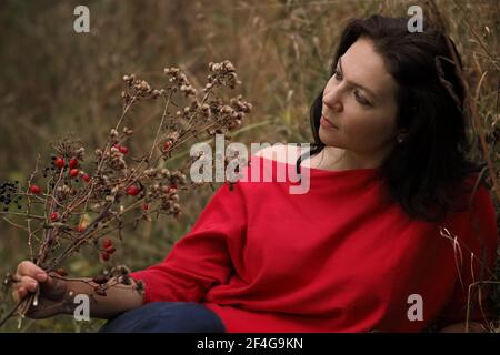 Schöne 30-jährige Frau entspannt im Herbstpark Stockfoto