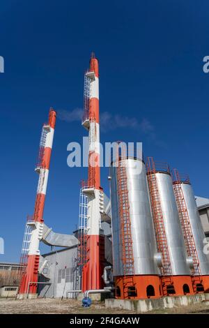 Außenansicht der Fernwärmeanlage mit Industriekaminen gegen den blauen Himmel. Rauch aus den Schornsteinen des Industriekraftwerks. Low-Angle-Ansicht. Stockfoto