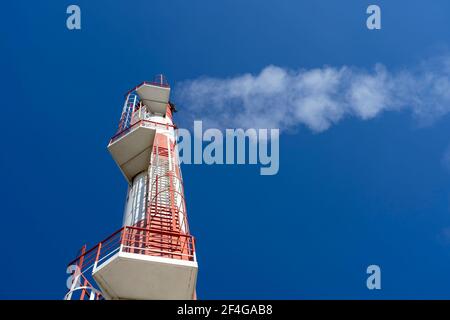 Nahaufnahme Rauchaufnahme aus dem Schornstein des Kraftwerks.Außenansicht der Fernwärmeanlage mit Industriekamin gegen den blauen Himmel.Low Angle View. Stockfoto