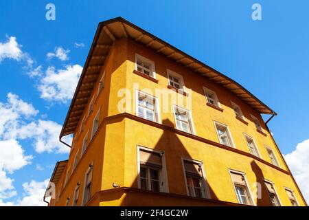 Dreistöckiges, gelb gefärbtes Wohnhaus Stockfoto